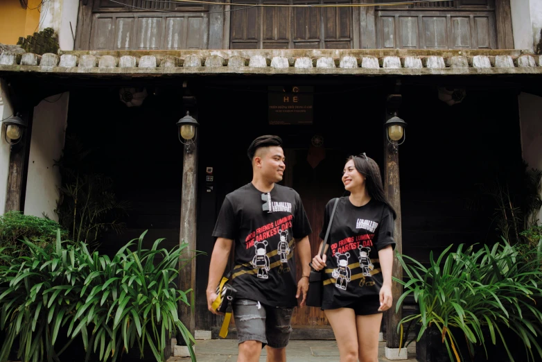 a couple is standing under a clock holding hands