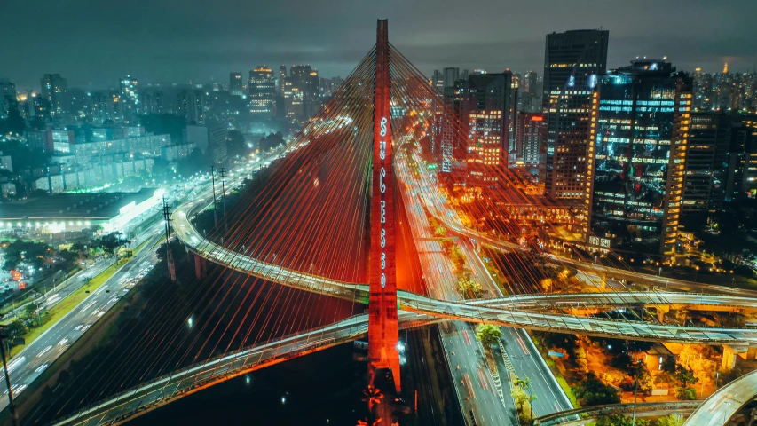 a night time view of the city with light trails and bridges