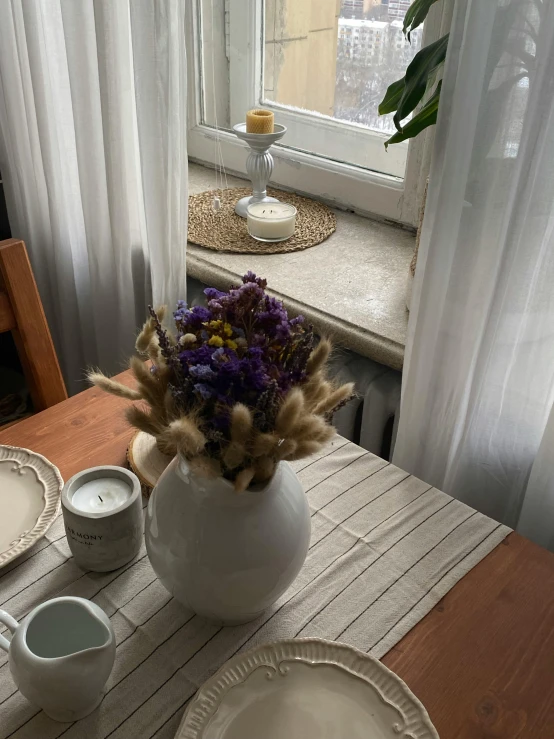 a vase of flowers sitting on a table next to a window