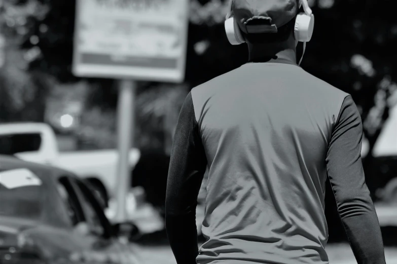 man wearing headphones walking down a city street