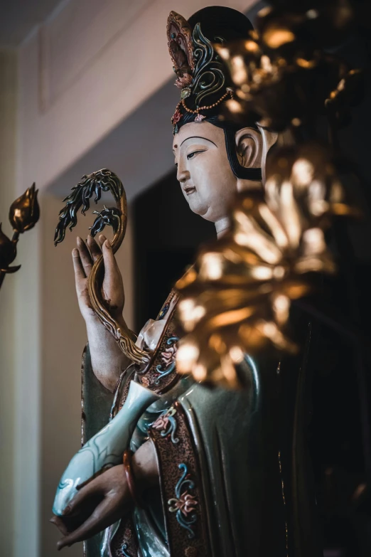 an ancient statue holds a gold decoration piece