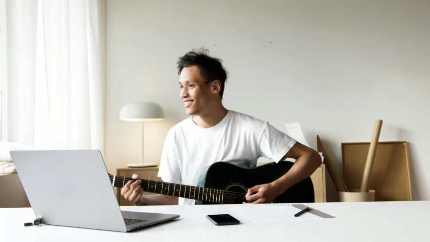 a person sitting at a table playing a guitar