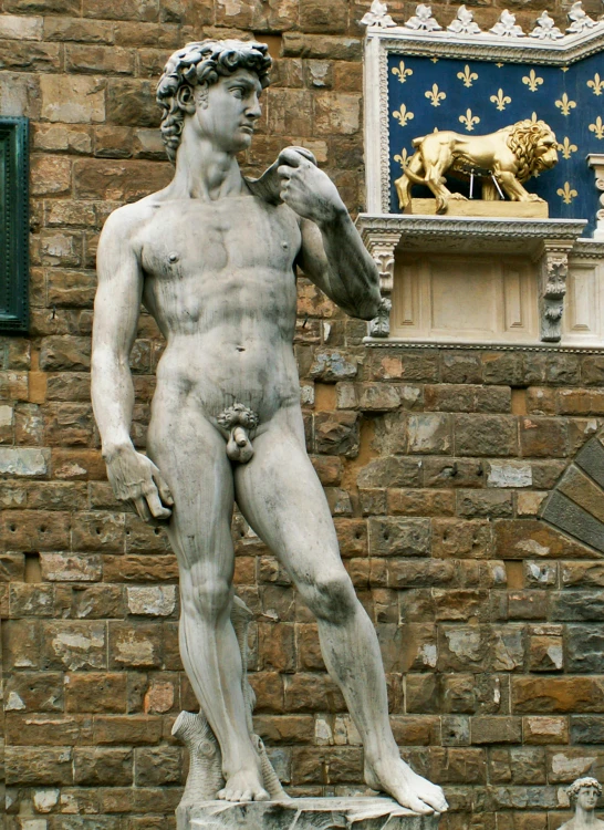 a statue of a man standing in front of a stone building