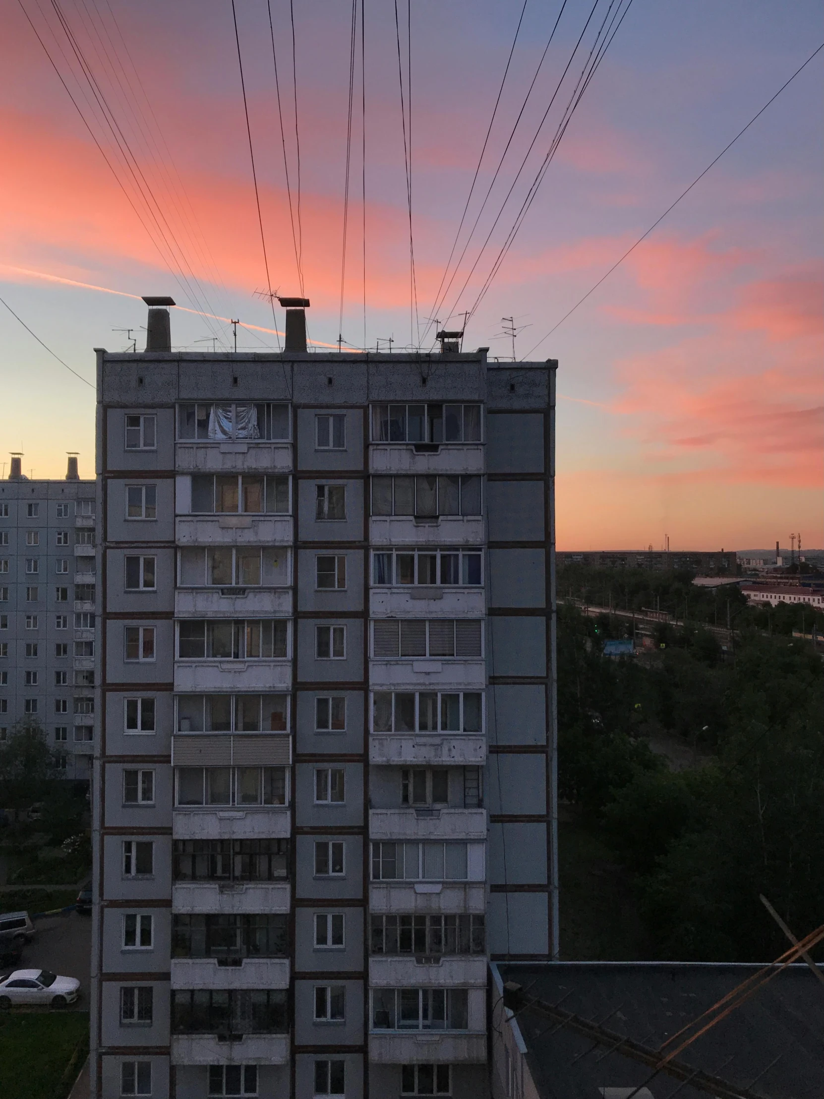 a multi story building with lots of windows and power lines above