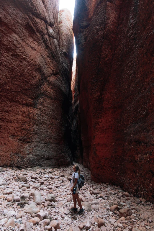 a young man is walking through a canyon