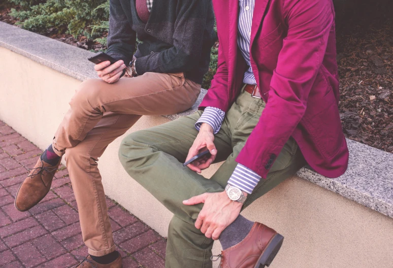 two young men sit and talk outside on the steps
