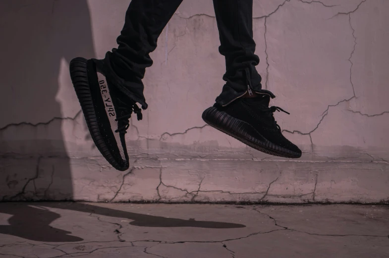 a person is leaping in the air wearing black sneakers