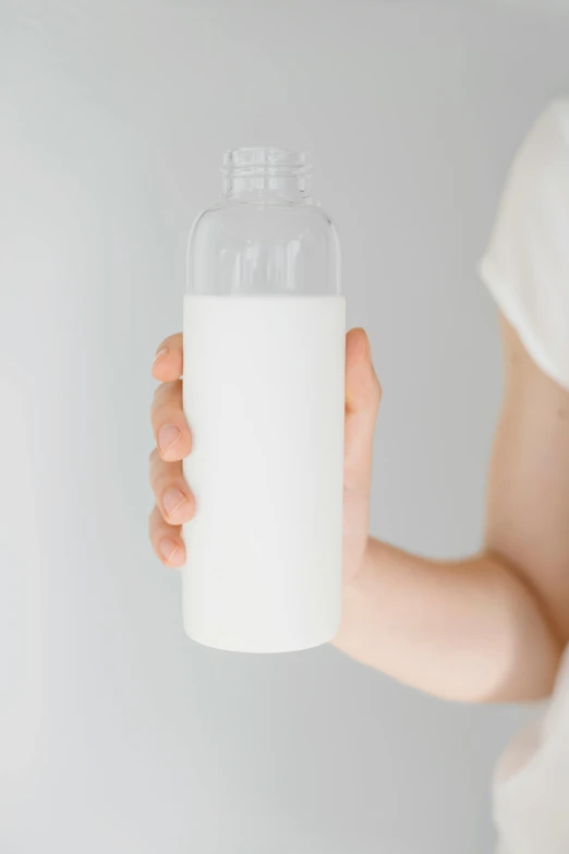 a person holding a bottle with some liquid