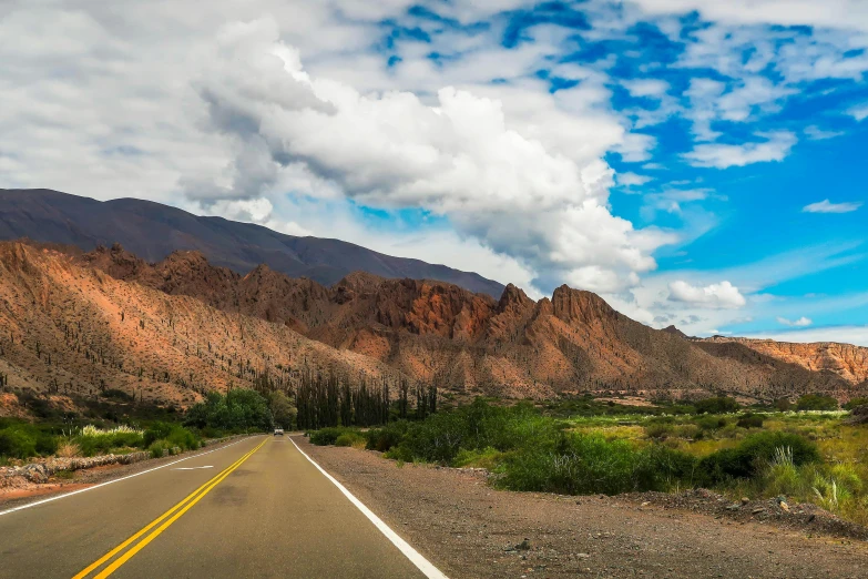 a big highway with a sky filled with clouds