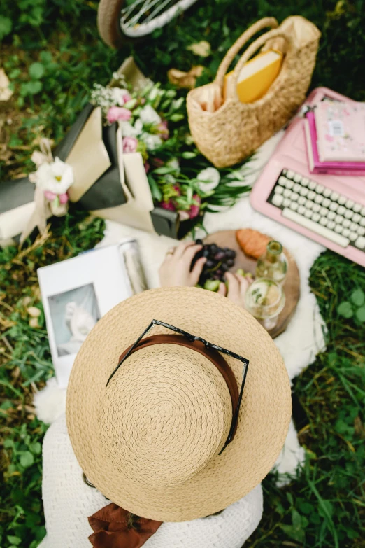 a hat on a chair and some books, pens, a keyboard and pictures