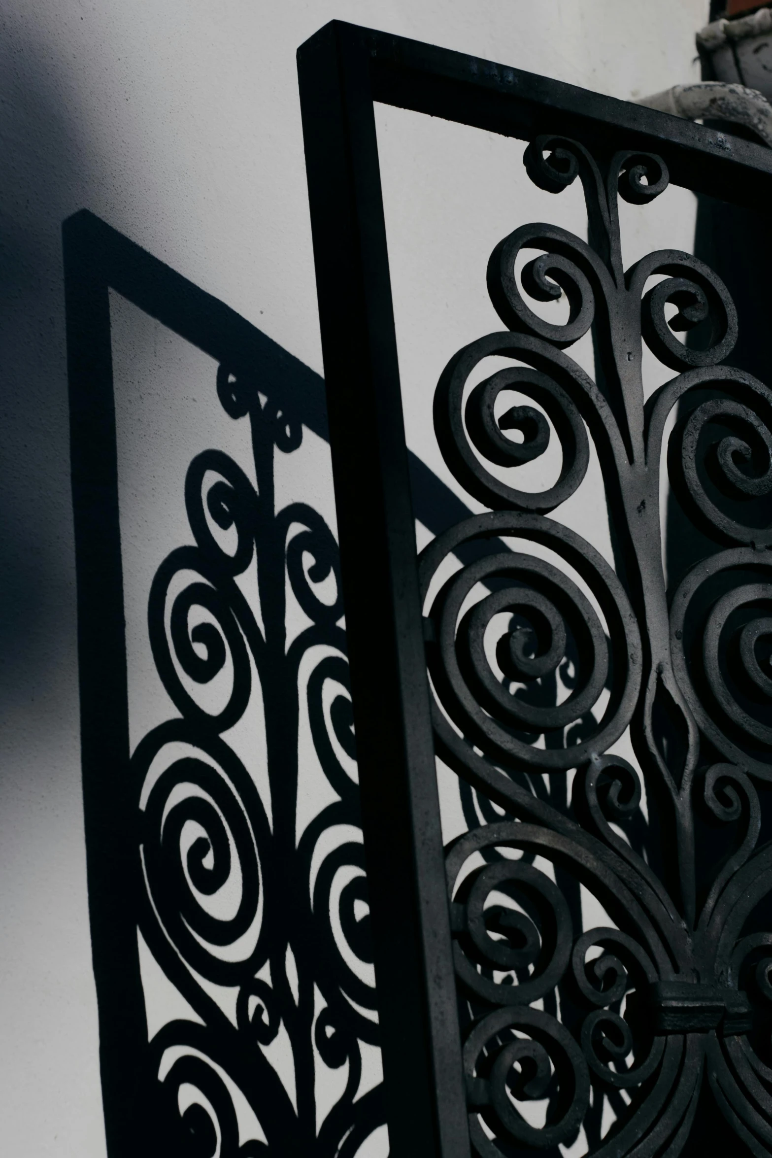 an ornamental ironwork window in front of a white wall