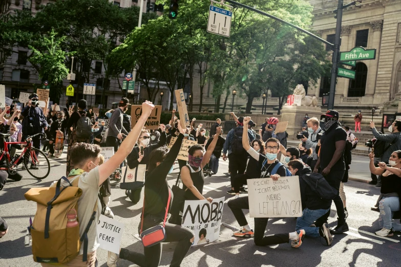 a group of people holding signs are dancing on a crowded street