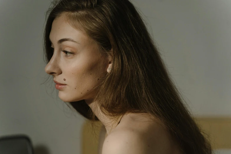 a woman with a large earring on looking in a mirror