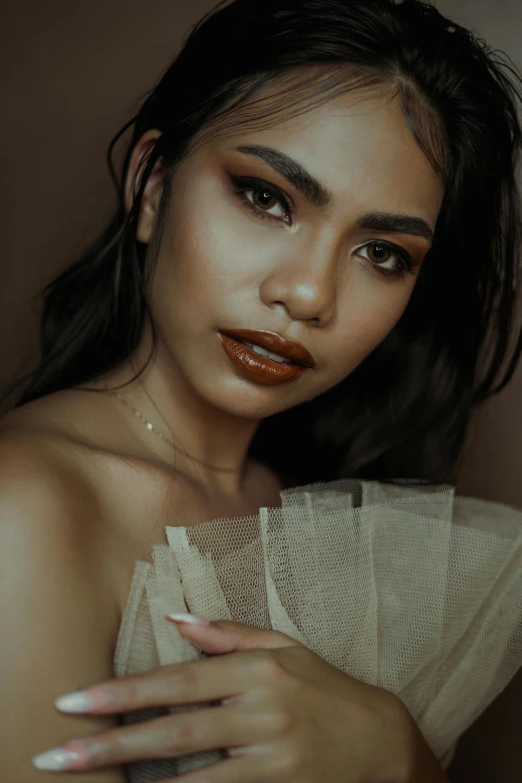 a woman with orange lipstick holding stacks of folded towels