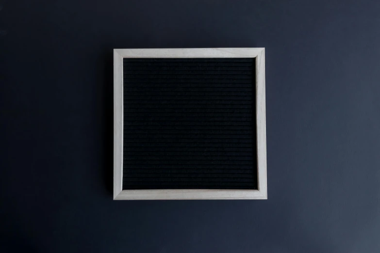 a white and black frame sitting on a dark wall