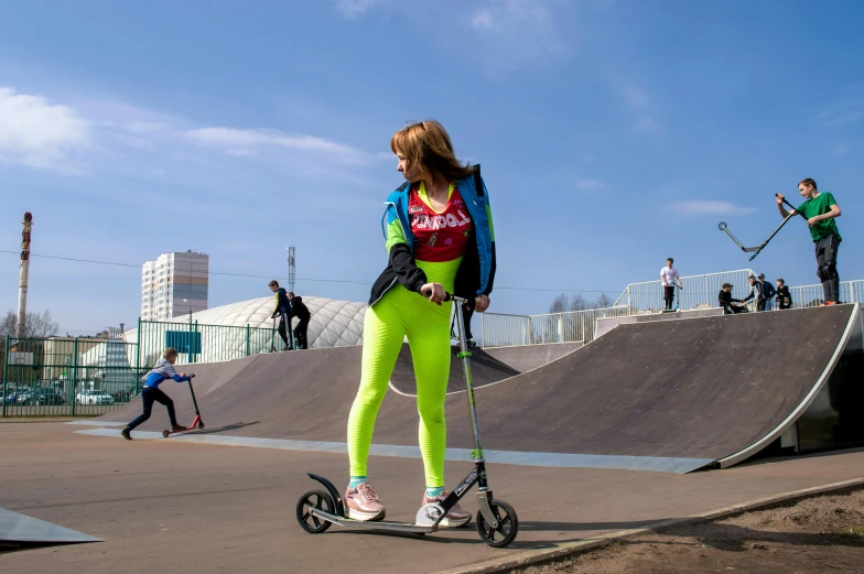 young lady with electric scooter rides around in a skate park