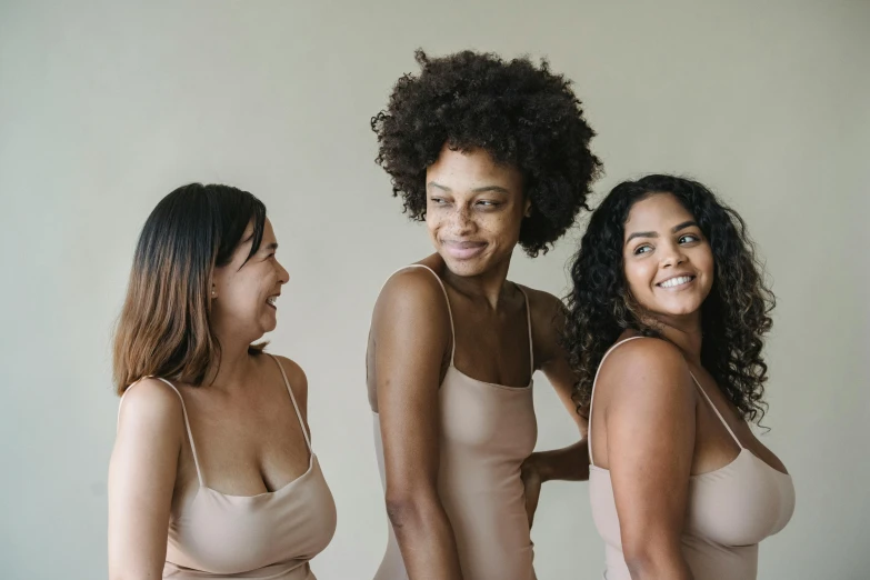 three women in s and lingerie smiling while posing for the camera