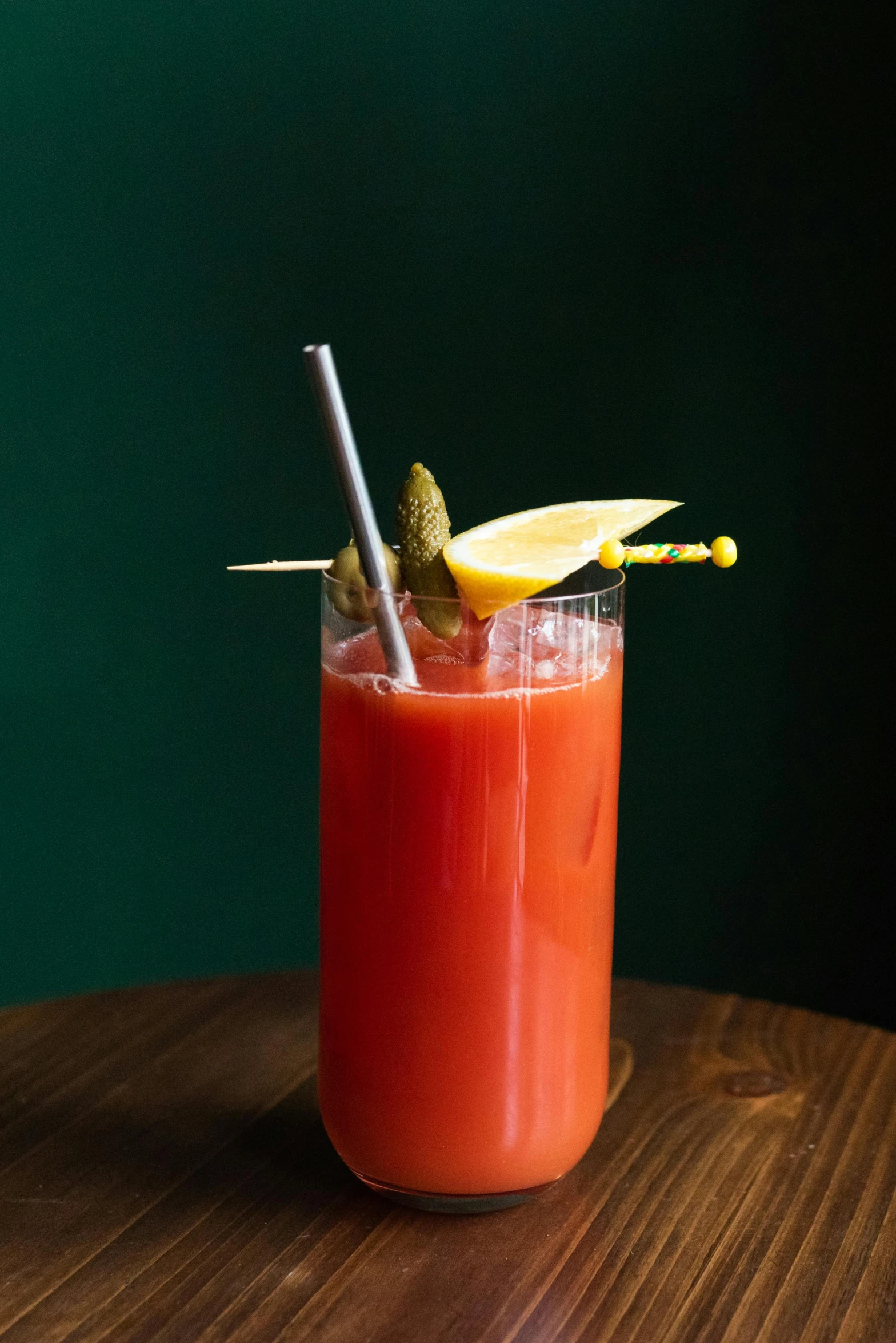 a glass of juice on a table with some sticks