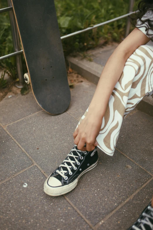 a young woman putting on her shoes with her hand