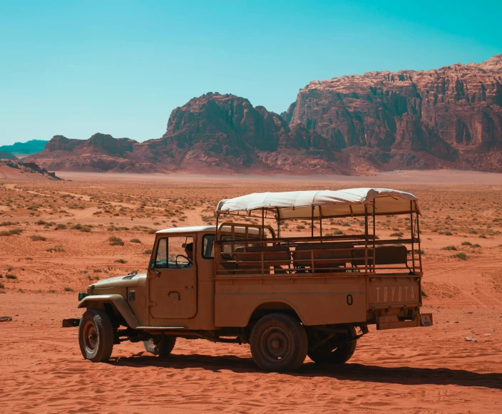 the safari truck is driving through the red desert