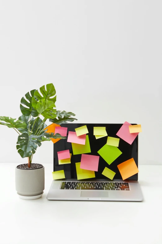 an assortment of colored sticky notes sit on a laptop