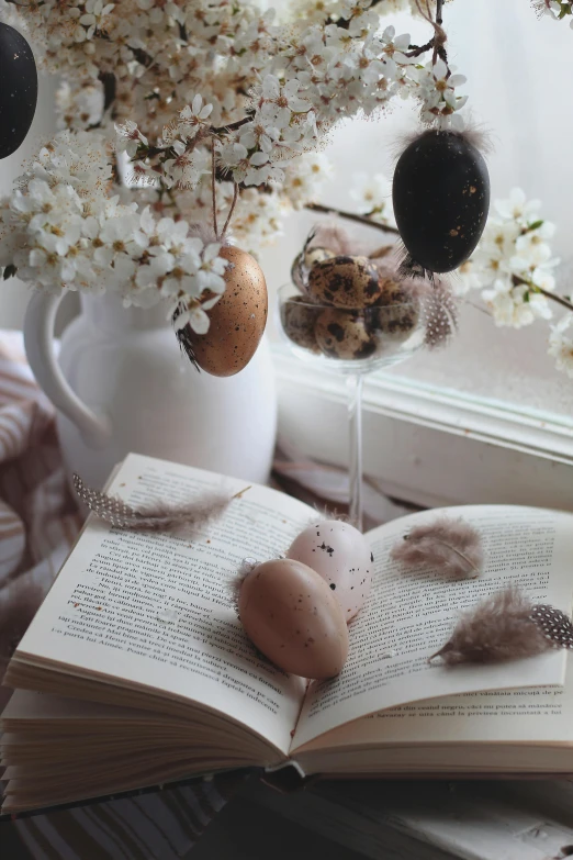 a book sitting on top of a table with flowers and eggs