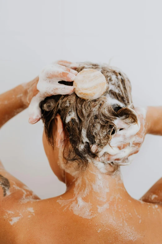 a person with their head covered with white frosting