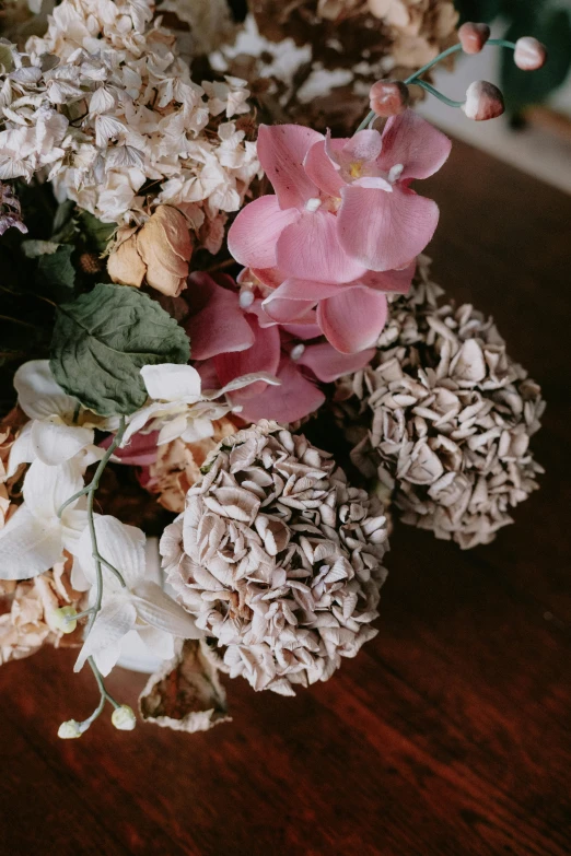 flowers and leaves are arranged in a vase