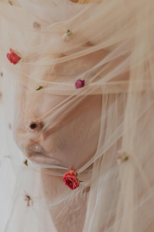 a close up of a person's wedding veil and flower