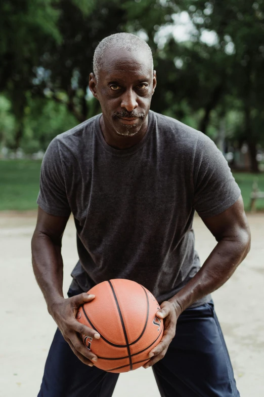 a man posing with a basketball in his hand