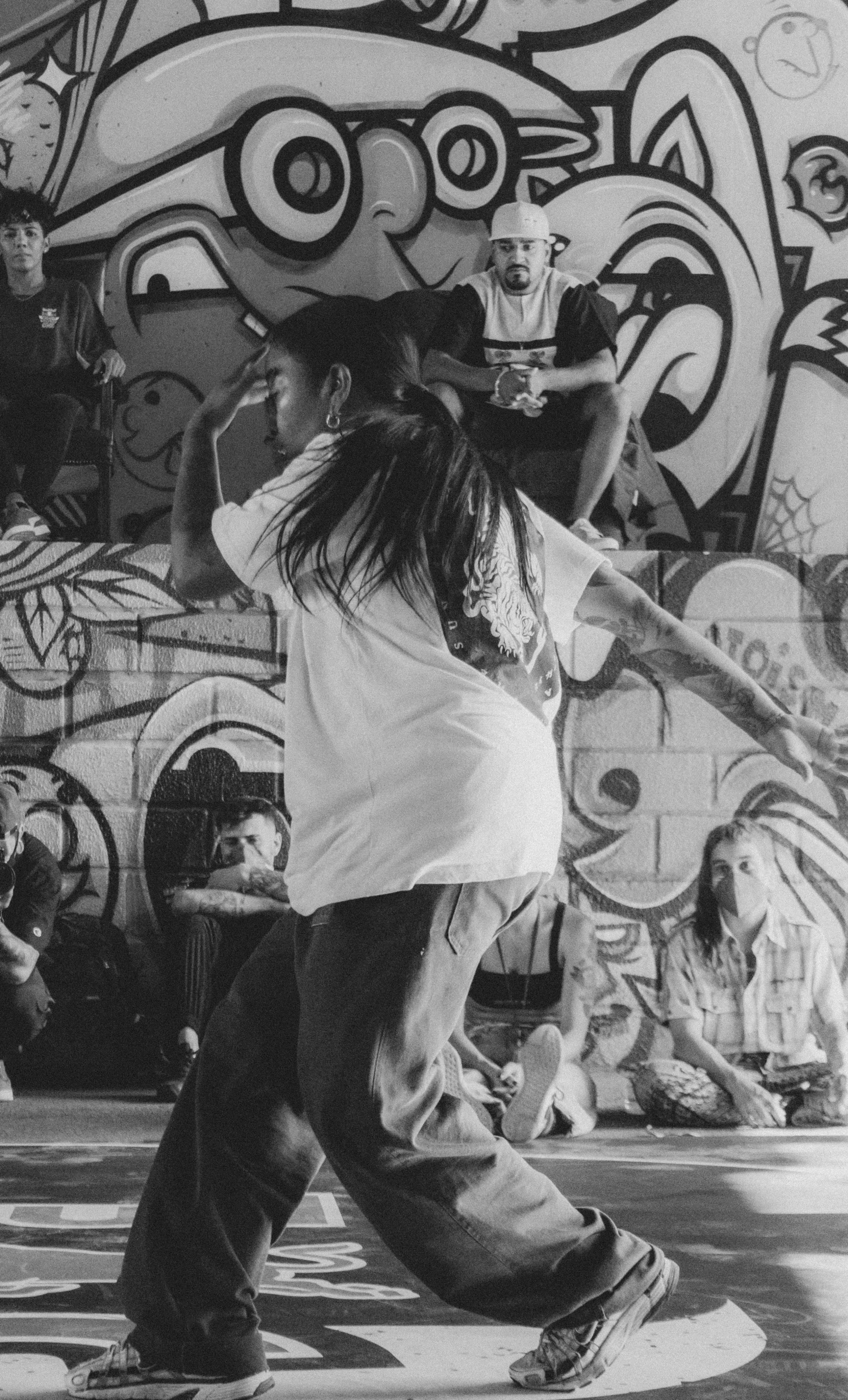 two people are skateboarding against a painted wall