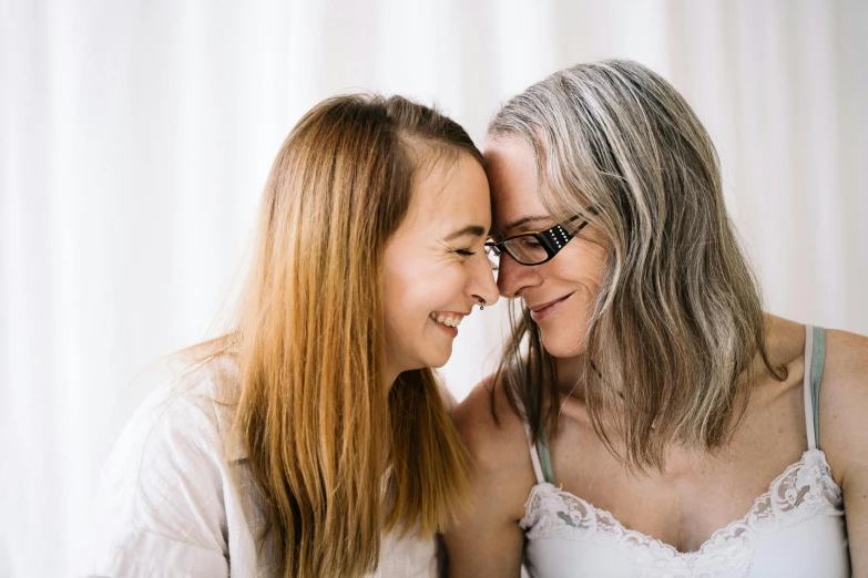 two women pose for a pograph while one holds her head over the other