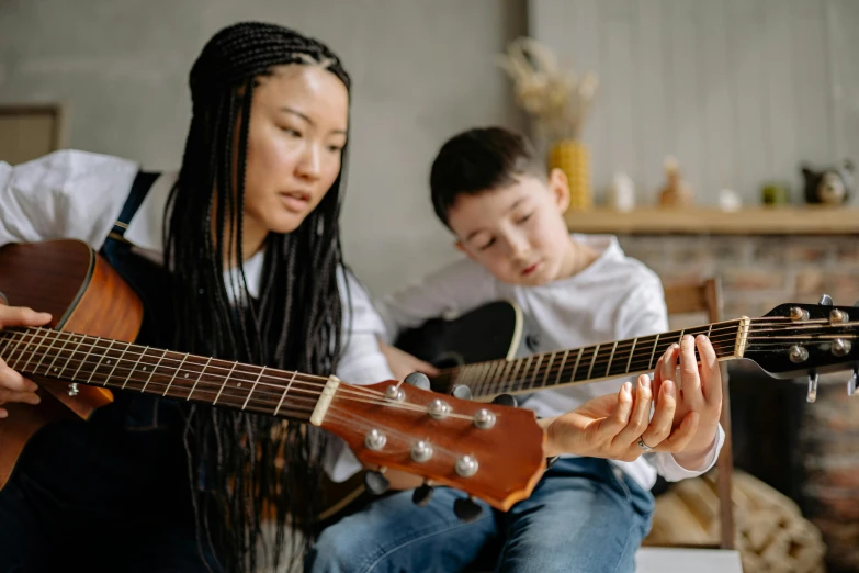 two children are playing guitar and singing