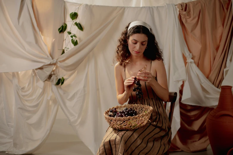 a woman in a brown dress with her hands together while looking at a beaded necklace