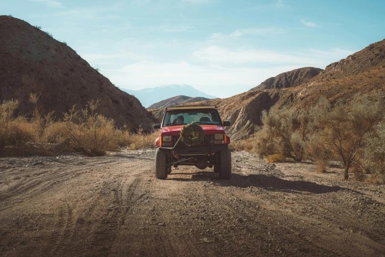 a red truck that is parked on a dirt road