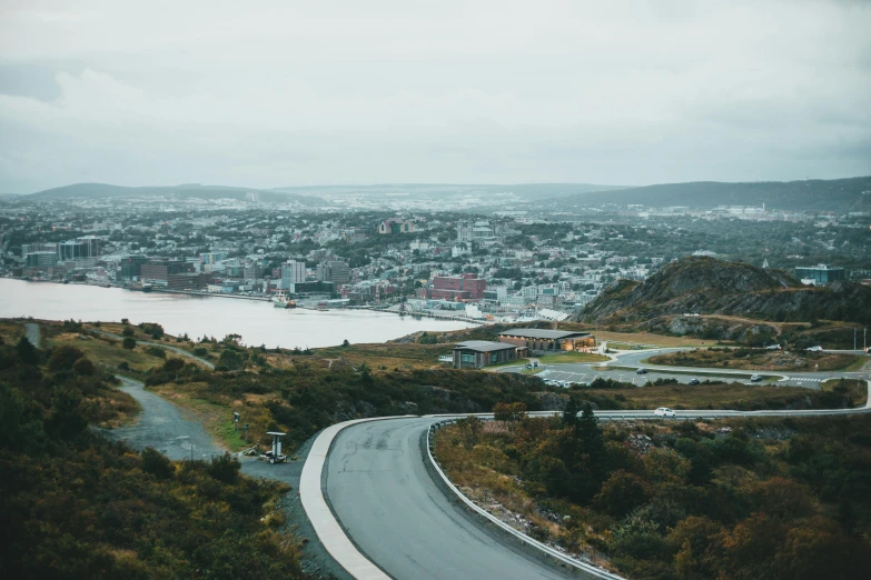 an aerial view of a road surrounded by trees and mountains