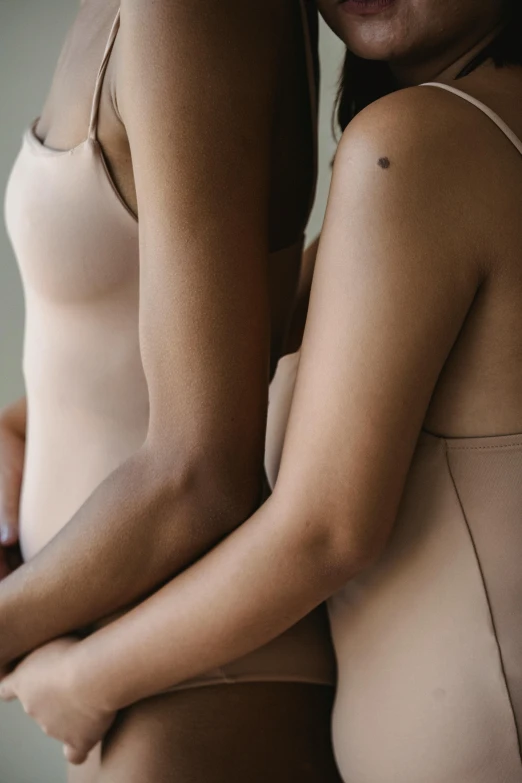 two women standing together with their arms crossed