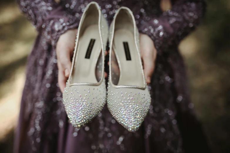 a close up of the shoes on a woman in a purple dress