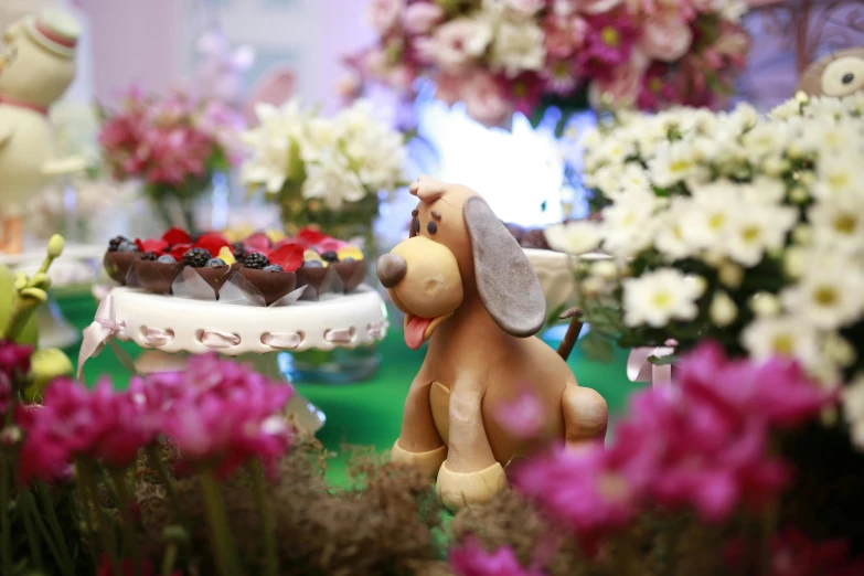 an elaborate cake displayed with flowers and other desserts