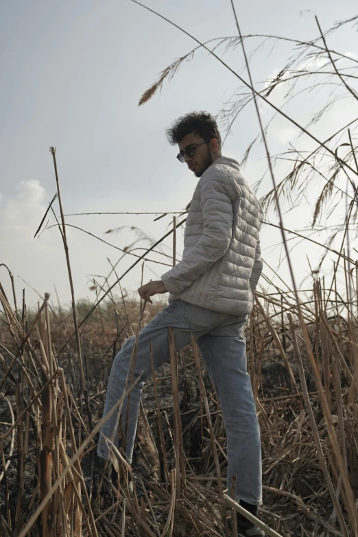 a man is walking through tall grasses