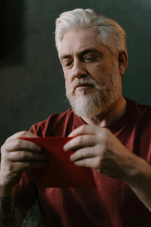 a man that has some sort of red paper in his hand
