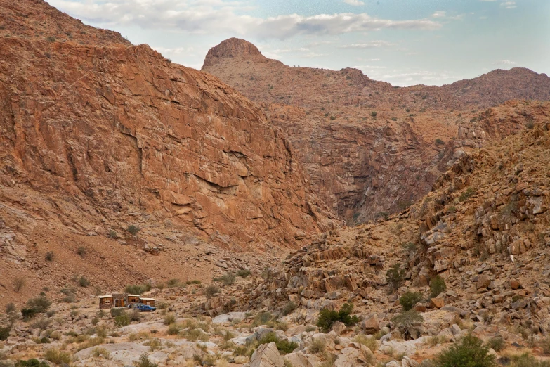 a big mountain with some animals grazing near by