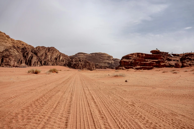 a dirt road passing between some large mountains