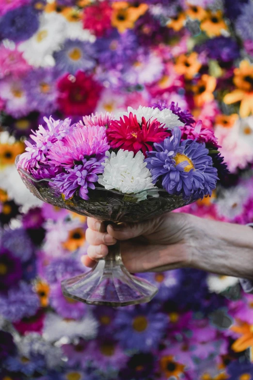 a man holding onto flowers in a martini glass