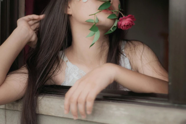 a woman blowing on the rose on her face