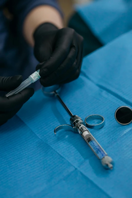 medical instruments with surgical gloves are on a blue cloth