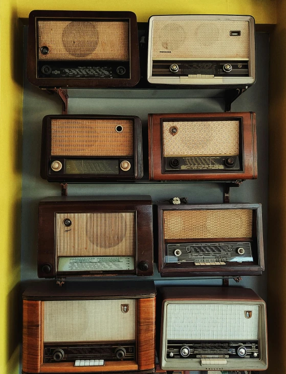 old radio radios and tv's are placed on the wall