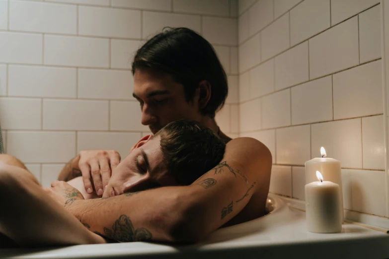 two men who are in a tub holding each other