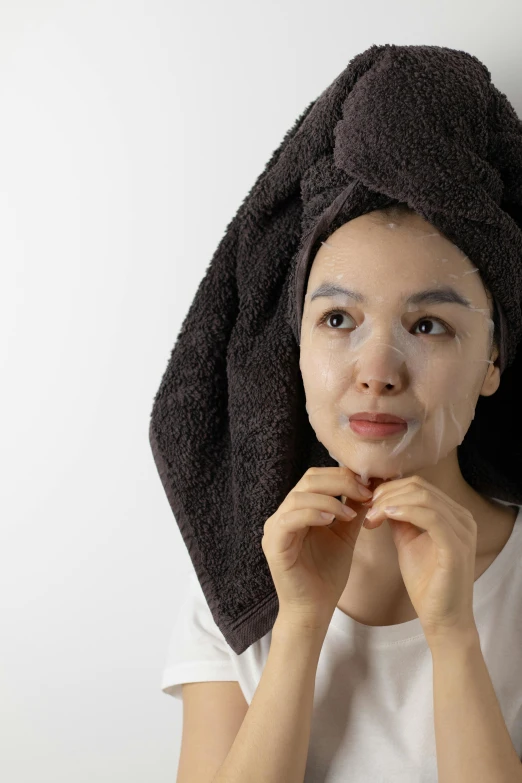 a woman holds out a mask on her face