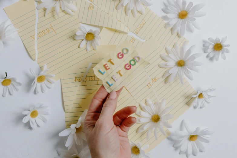 someone holding an letters stick and a flower